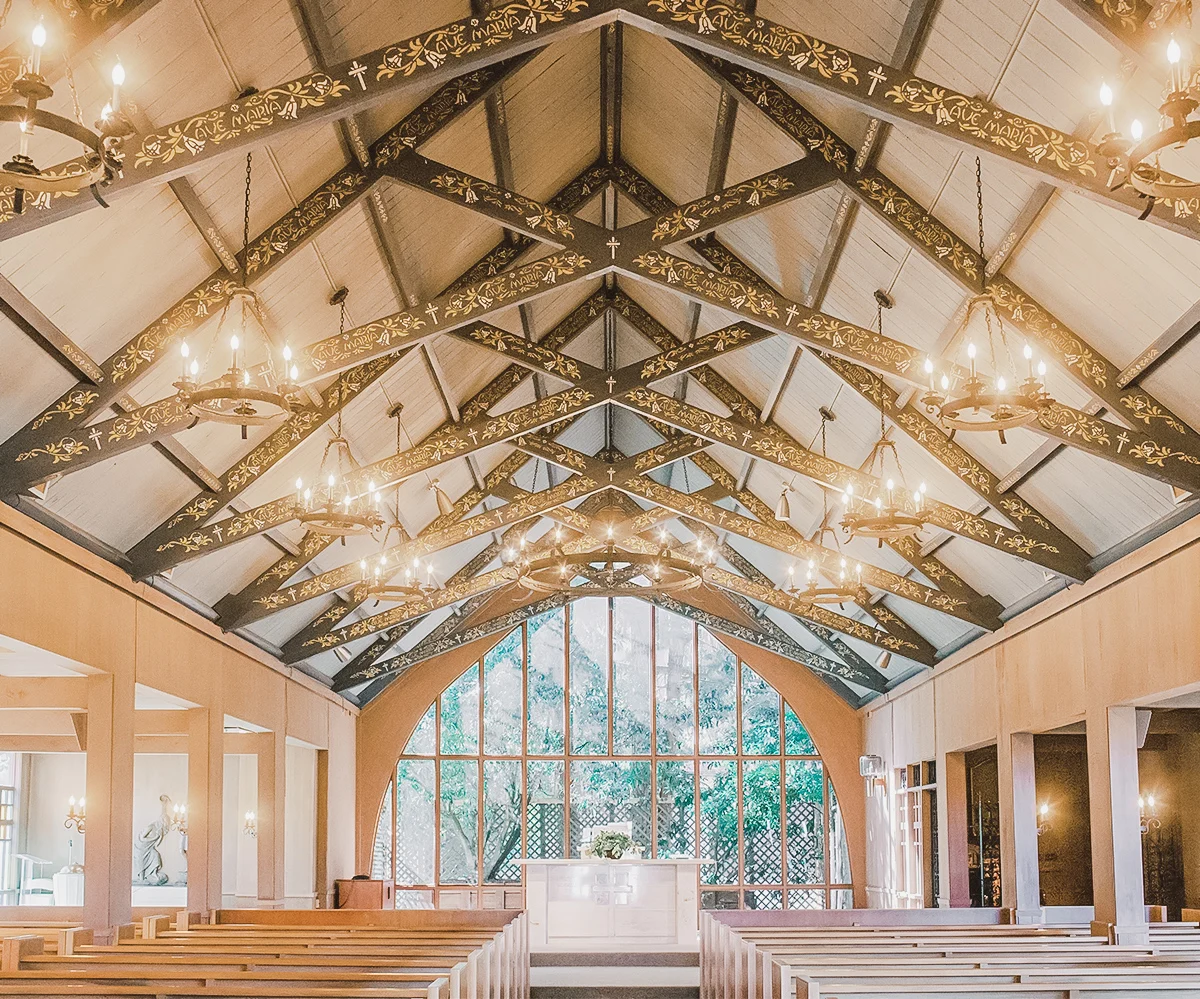 Chapel of Our Lady interior with hand-painted beams and arched glass wall